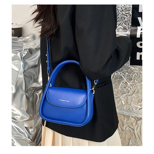 Close-up of royal blue faux leather mini crossbody bag with silver lettering detail