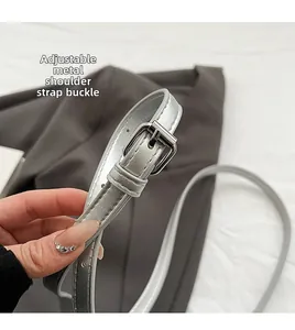 Détail de la bandoulière en similicuir argenté avec boucle en métal réglable et grain fin