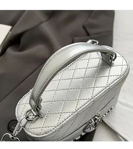 Détail du sac bandoulière argenté matelassé avec poignée épaisse et anneau en D en métal