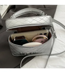 Vue détaillée de l'intérieur d'un sac argenté matelassé avec rangement cosmétique