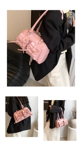 Detailed close-up of pink bow hobo bag with glossy finish and double handle straps