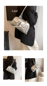 Close-up of a silver bow detail on a minimalist metallic shoulder bag for women