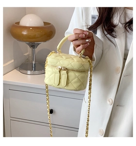 Detailed view of yellow PU leather mini bag with diamond quilting and gold chain strap