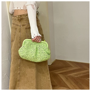 Detail of neon green hand-woven straw clutch bag with a unique textured frame closure