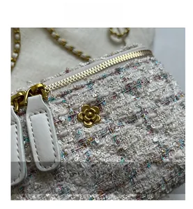 Vue macro de la texture en tweed blanc avec décoration en métal de fleur de camélia