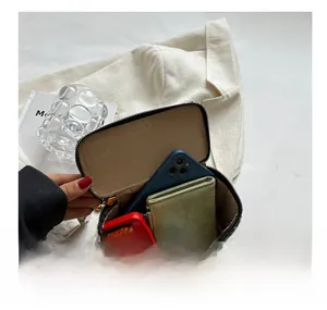 Détail de l'intérieur du mini sac pied-de-poule rempli de téléphone et d'accessoires
