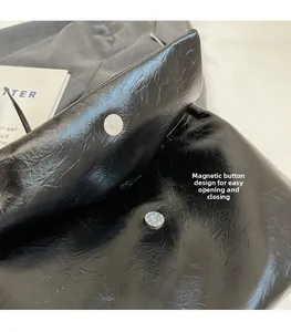 Gros plan d'un sac cabas noir en cuir plissé avec boucle magnétique argentée