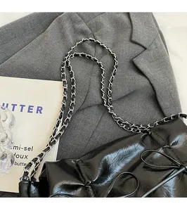 Détail du sac cabas plissé noir avec bandoulière en chaîne argentée et texture cuir