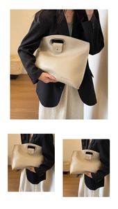 Detail of minimalist beige tote with oval metal handle and debossed Originally logo