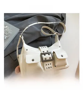 Close-up of white patent leather bag featuring metal rivets and large square buckle detail