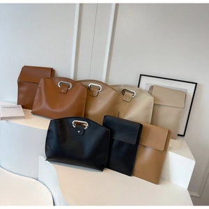 Detailed arrangement of minimalist leather clutches and briefcases in earthy tones