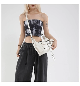 Detailed view of white punk crossbody bag with metallic buckles and eyelet strap