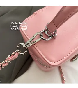 Detail of pink pebbled leather handbag featuring detachable silver metal clasp and chain strap