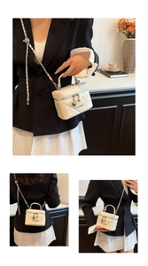 Detail of cream quilted mini handbag featuring silver heart charm and chain strap