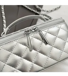 Detail of silver quilted handbag featuring dual smooth zippers and metallic texture