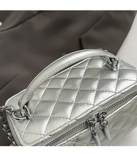 Detail of silver quilted PU leather handbag with metallic chain and double zipper