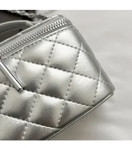 Macro detail of silver quilted leather texture with smooth metallic zipper finish