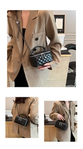 Detailed view of black quilted leather mini handbag with silver chain and zip closure