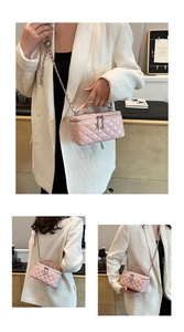 Detailed view of pink quilted box bag with metal chain strap and dual zippers