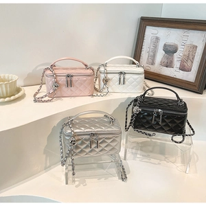 Detailed display of four colors of quilted mini chain bags with top handles and zippers