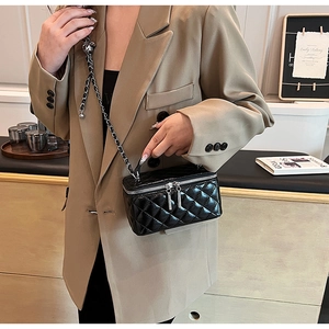 Close-up of black quilted leather texture and silver double zipper chain bag detail