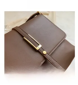 Nahaufnahme der braunen Kunstleder-Schultertasche mit goldener Schnalle und feinen Nähten