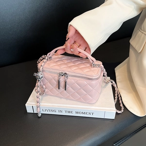 Pink quilted leather crossbody box bag with silver chain strap and metal ball charm