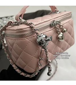 Detail of pink quilted leather bag with adjustable silver chain and metal heart charm