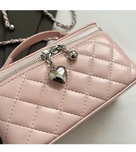 Close-up of pink quilted leather texture with silver heart pendant and smooth zipper