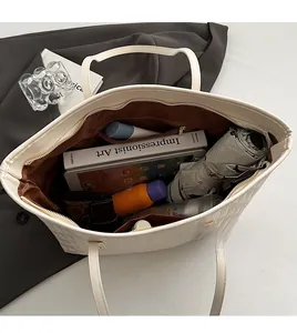 Inside view of beige quilted tote bag showing spacious capacity for books and umbrella