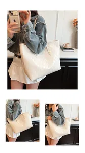 Detailed close-up of white quilted tote bag with diamond stitching and long shoulder straps