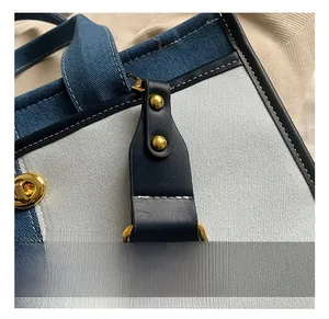 Gros plan du sac en denim patchwork avec ferrures dorées et surpiqûres contrastées