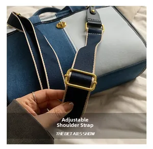 Détail de la bandoulière en tissu réglable avec boucle en métal doré sur le sac fourre-tout