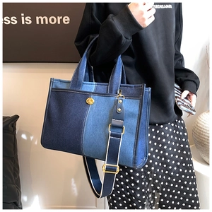 Détail d'un sac cabas en denim patchwork avec fermoir rotatif doré et bandoulière