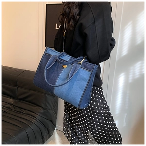 Détail du sac cabas en jean avec blocs de couleurs et finitions dorées en mode de vie