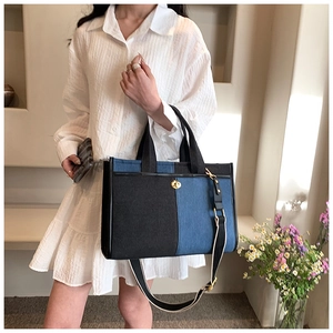 Détail du sac cabas en jean bicolore avec fermoir doré et bandoulière en toile rayée