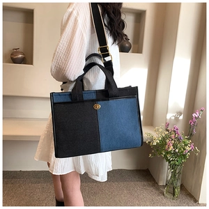 Détail du sac cabas en denim bicolore avec fermoir rotatif doré et large bandoulière