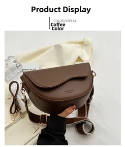 Detail of a brown PU leather saddle bag with wide fabric strap and golden hardware