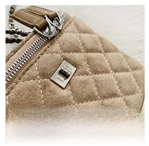 Detail shot of khaki quilted suede handbag with silver metal twist lock and chain strap