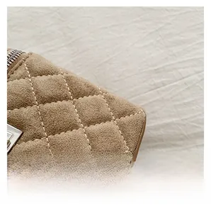 Detail shot of khaki suede texture with diamond quilted stitching on a casual box bag
