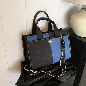 Sac fourre-tout en denim bicolore avec fermoir en métal et bandoulière tissée