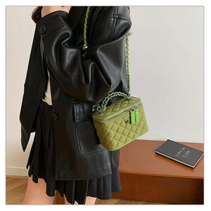 Grass green quilted box bag with double zipper and chain strap shown on a model