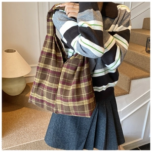 Detailed view of checkered knit tote bag showing thick texture and warm brown tones