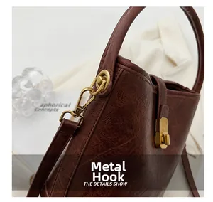 Détail du sac seau en cuir marron montrant le crochet et le fermoir dorés