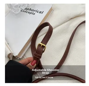 Détail de la bandoulière réglable en cuir marron foncé avec boucle dorée pour sac seau chic