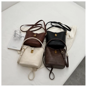 Flat lay of four vintage bucket bags in brown, black, beige, and coffee with gold locks