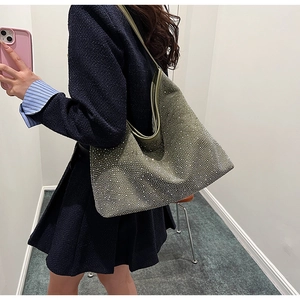 Detalle de bolso tote de ante verde oliva con adornos de pedrería plateada brillante