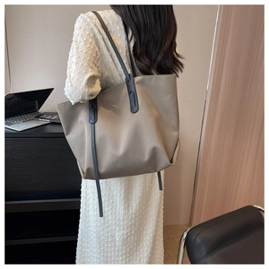 Gros plan du grand sac cabas Oxford kaki porté à l'épaule dans un cadre de bureau