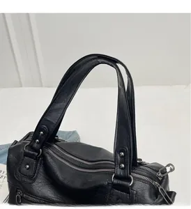 Détail de la poignée confortable et du double zip sur le sac de voyage vintage noir