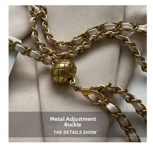 Detail of woven chain strap with adjustable gold ball buckle and leather accents